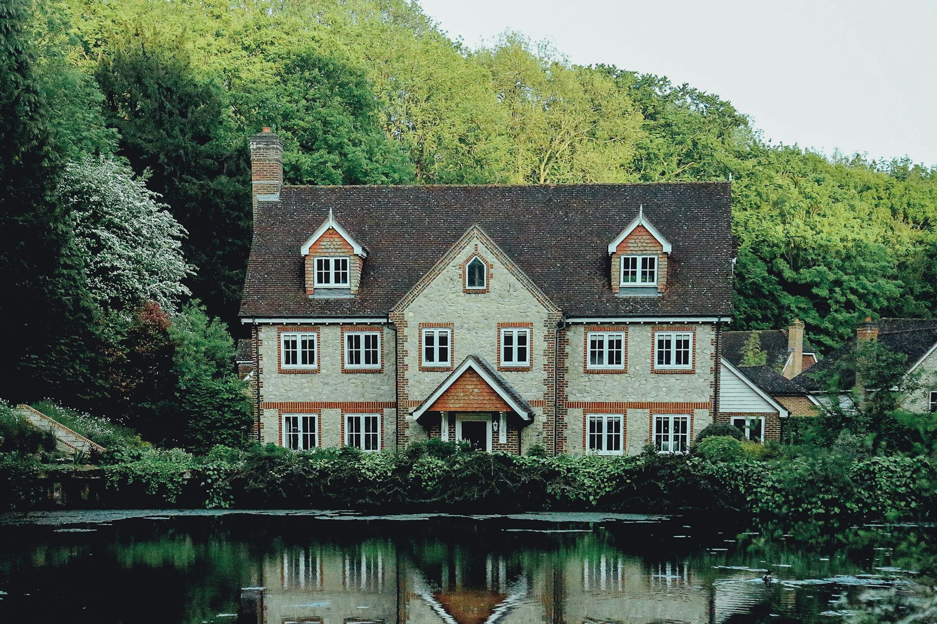 Willowbank House seen across the water, surrounded by trees