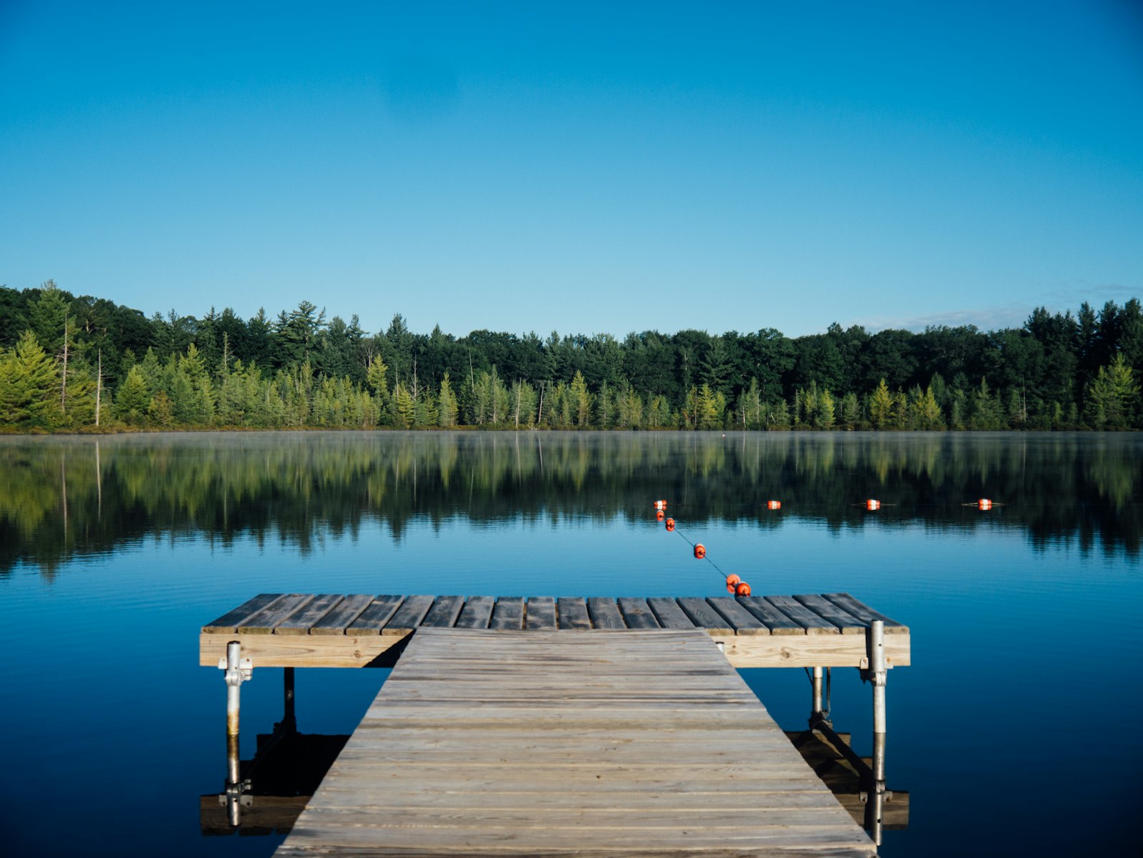 A wooden jetty on still water at dusk