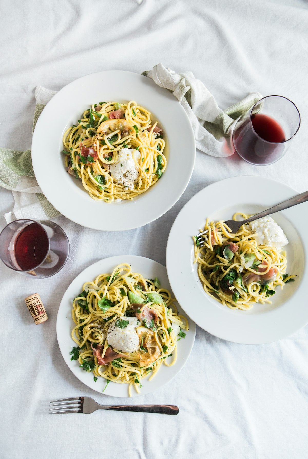 Plates of fresh pasta on a white tablecloth