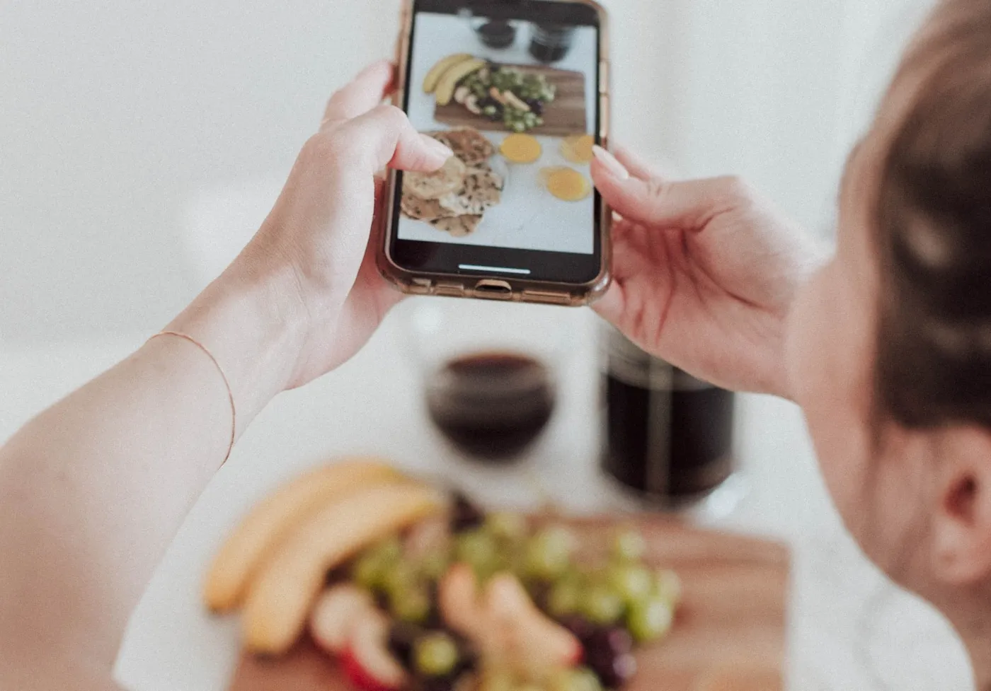 A business owner photographing food on a phone before posting it to social media