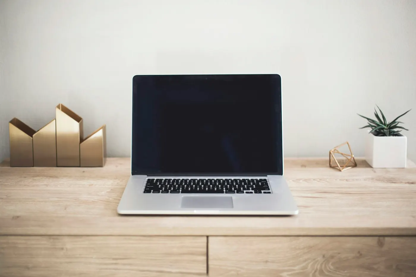 A laptop on a clean, bright desk at home, ready to build a first small business website