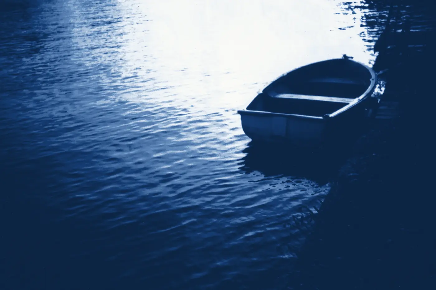 A rowing boat moored in shade, printed in Prussian blue.